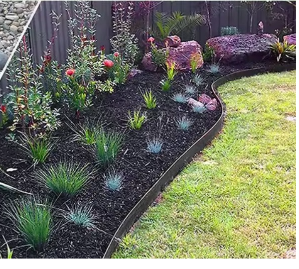 Black garden edging holding a planted bed back from the lawn