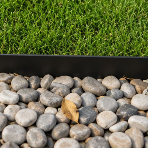 Finished garden edging holding grey pebbles back from the lawn